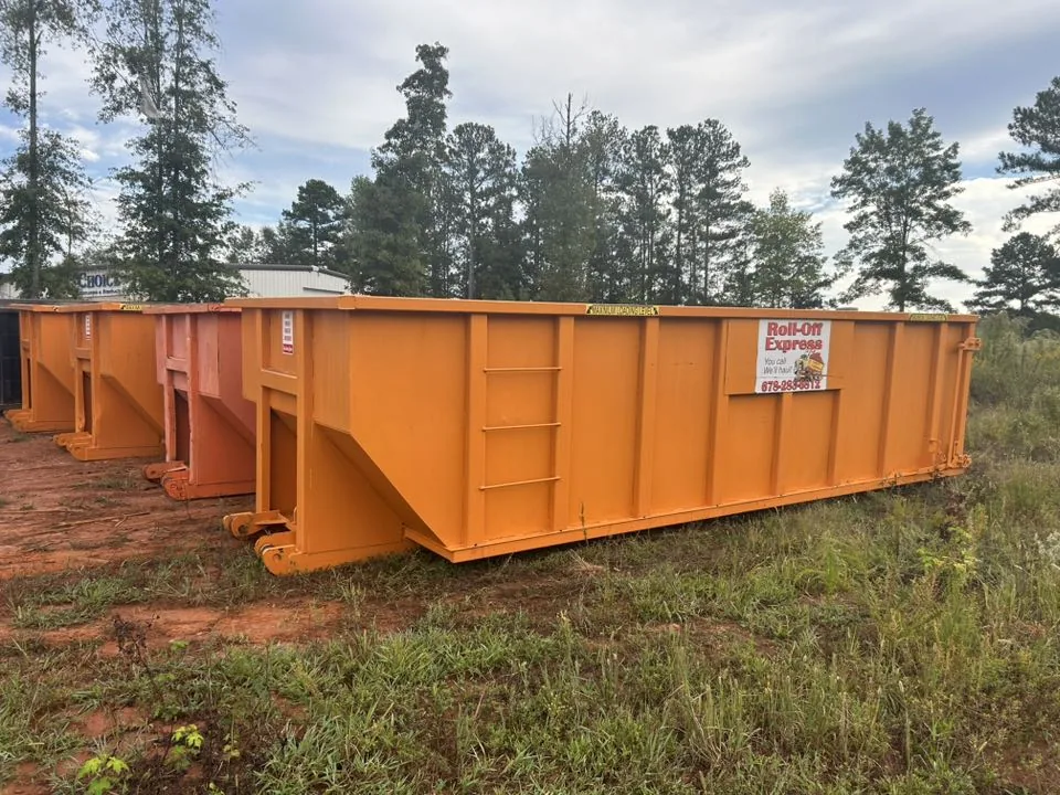 Several orange Roll-Off Express dumpsters lined up